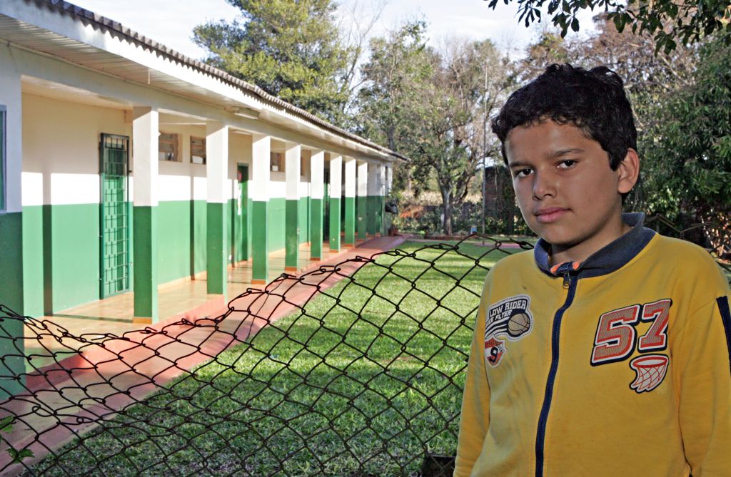 Maurício da Silva, de 13 anos, em frente da antiga escola rural em Foz do Iguaçu, agora fechada: ele se sente melhor no novo colégio, onde fez mais amizades | Christian Rizzi/Gazeta do Povo