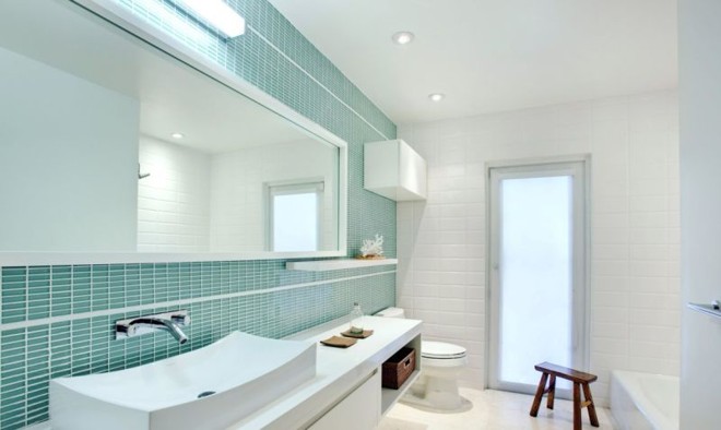 Para esse banheiro, o arquiteto Filipe Bender Almeida escolheu pastilhas de vidro na cor verde água, para contrastar com o branco | 