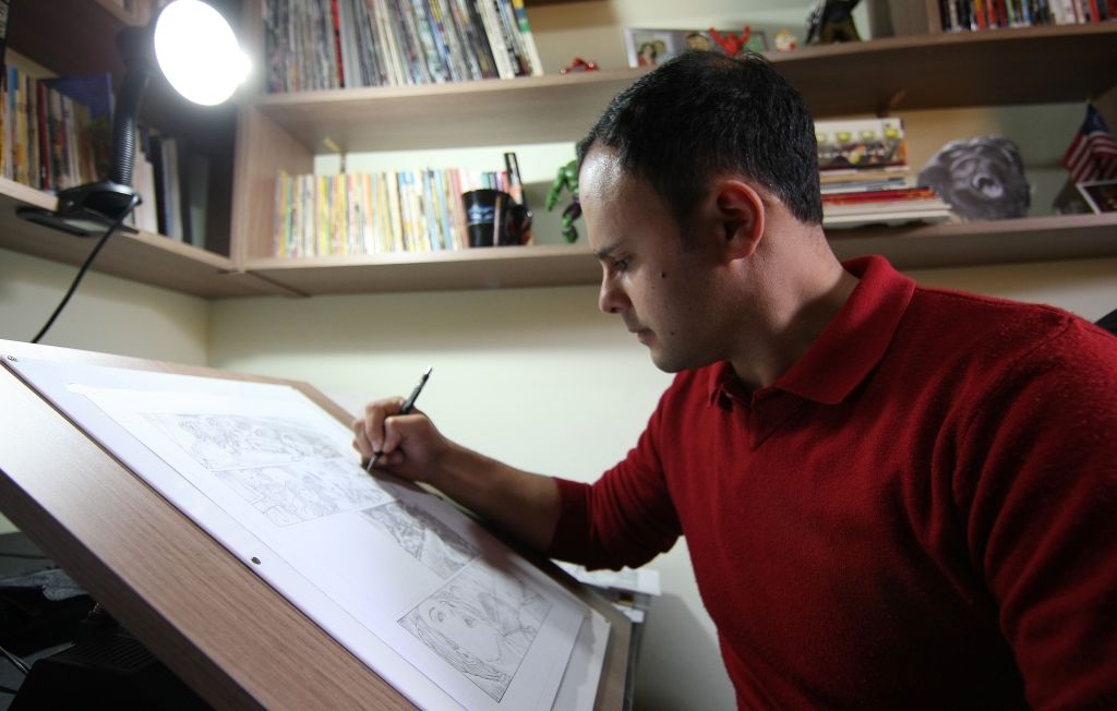 Carlos Magno e sua prancheta: 15 horas por dia para dar conta das páginas. Trabalho e filho o impedem de ler quadrinhos há três anos | Valterci Santos/Gazeta do Povo