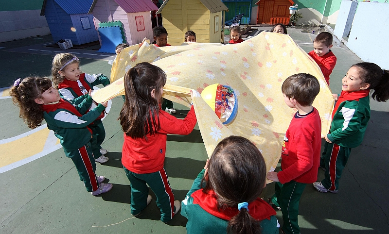 As crianças do Centro Municipal de Educação Infantil de Curitiba jogam lençobol, em que todos têm de segurar o lençol e fazer com que a bola entre no cesto | Valterci Santos/ Gazeta do Povo