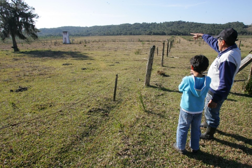 Seu Ronei Azevedo, caseiro do antigo haras que será a nova casa coxa-branca, mostra o local ao lado do filho | Ivonaldo Alexandre / Gazeta do Povo