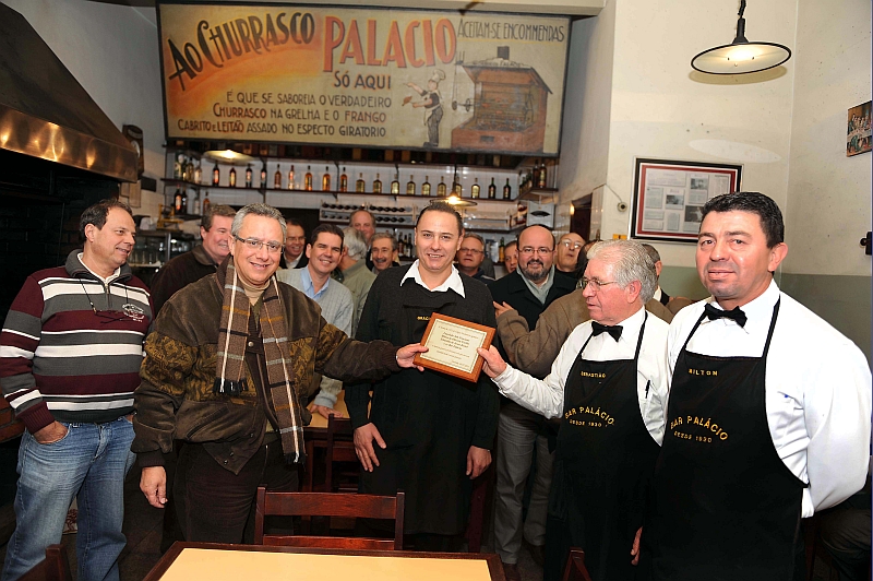 Os alunos da turma de 1972 do Colégio Medianeira homenagearam na terça-feira os garçons do tradicional Bar Palácio com uma placa. Há 33 anos eles se reúnem no restaurante toda primeira terça-feira de cada mês. A placa com os dizeres: A turma de 1972 do Colégio Medianeira agradece Laurindo Suk Graciano, Milton de Oliveira Coelho e Sebastião de Jesus Bestel pela maneira sempre gentil e profissional com que nos têm atendido desde o século passado foi entregue pelo engenheiro Thadeu Castello Branco (à esq., de cachecol). Ao fundo, à direita, o advogado Manoel Lacerda Carneiro | Julio Cesar Souza
