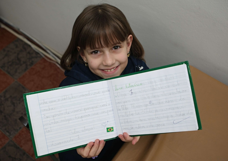 Laura sofreu para aprender a letra cursiva e agora está feliz por ter conseguido abandonar o caderno de caligrafia | Aniele Nascimento / Gazeta do Povo