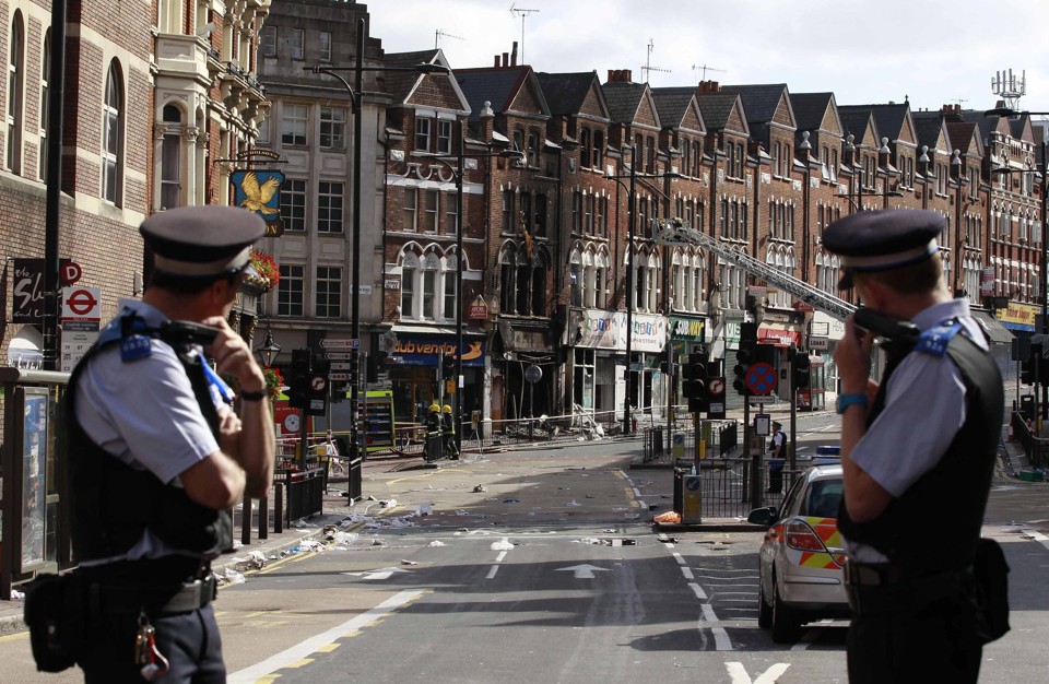 Policiais britânicos observam limpeza das ruas após onda de violência | REUTERS/Stefan Wermuth