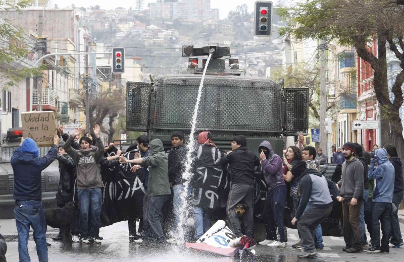 Estudantes formam barreira humana para barrar passagem de veículo da polícia, em protesto contra a política educacional do governo | Eliseo Fernandez/Reuters