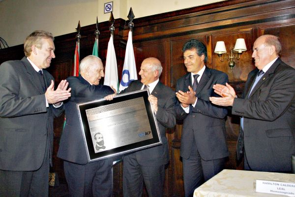 Sob os aplausos do prefeito Luciano Ducci (à esq.), do governador Beto Richa e do presidente da Associação Médica do Paraná, o médico e empresário Hamilton Calderari Leal, fundador do Hospital Santa Cruz, recebe a Comenda Barão do Serro Azul das mãos do presidente da Associação Comercial do Paraná, Edson Ramon. A cerimônia lotou o principal salão do Graciosa Country Club nesta quinta-feira | Felipe Rosa