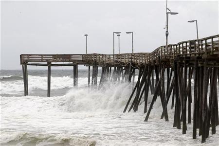 Ondas atingem pier em Avon, na Carolina do Norte. As primeiras chuvas do Furacão Irene já se aproximam da costa das Carolinas, informou o Centro Nacional de Furacões (NHC) dos Estados Unidos | REUTERS/Jose Luis Magana