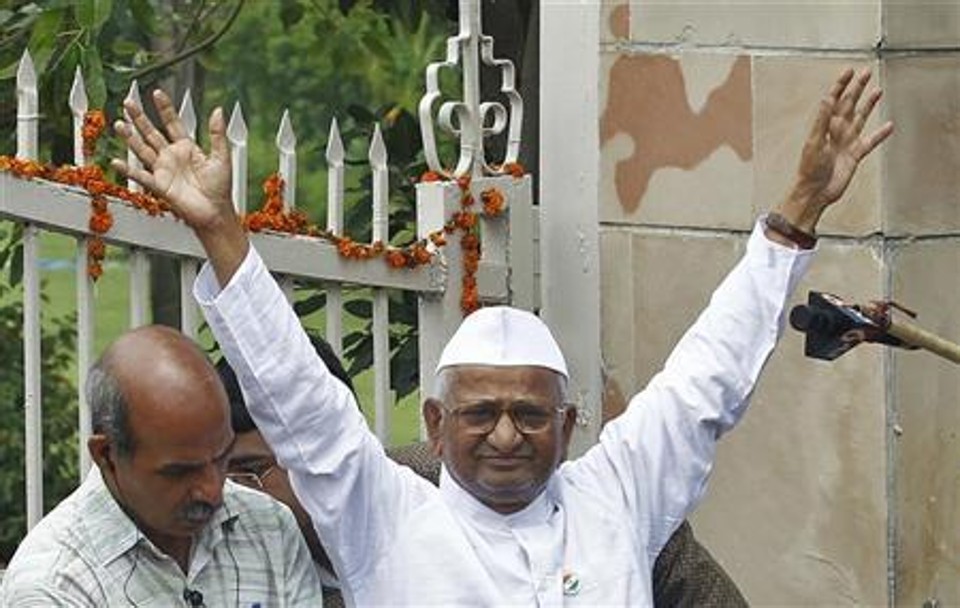 Ativista indiano Anna Hazare acena aos simpatizantes ao deixar a prisão de Tihar, em Nova Délhi. Uma multidão vasta e jubilante aplaudiu na sexta-feira o ativista, que deixou a prisão para iniciar uma greve de fome em público, exigindo leis mais severas contra a corrupção, num movimento popular que deixou o governo acuado | REUTERS/Adnan Abidi