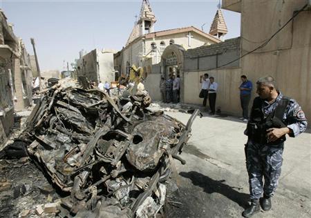 Policial inspeciona veículo queimado após ataque a bomba em frente a uma igreja no centro de Kirkuk, no Iraque | Reuters
