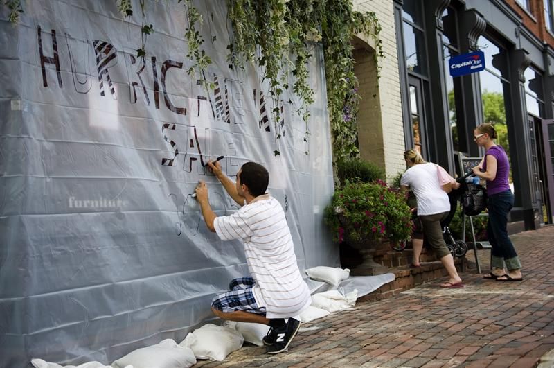 No estado da Virginia, funcionários de uma loja protegem vitrine contra furcão usando plástico | EFE/Shawn Thew