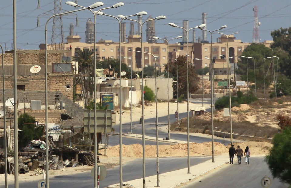 Rebeldes caminham por estrada em direção a refinaria de óleo em Zawiyah, na Líbia | REUTERS/Bob Strong