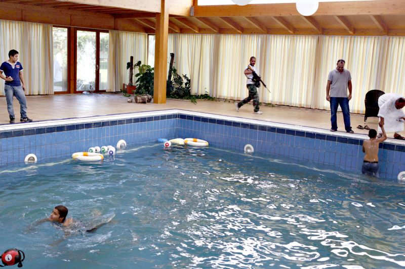 Rebeldes nadam em piscina da residência da filha de Kadafi, Aisha, em Trípoli | Youssef Boudlal/Reuters