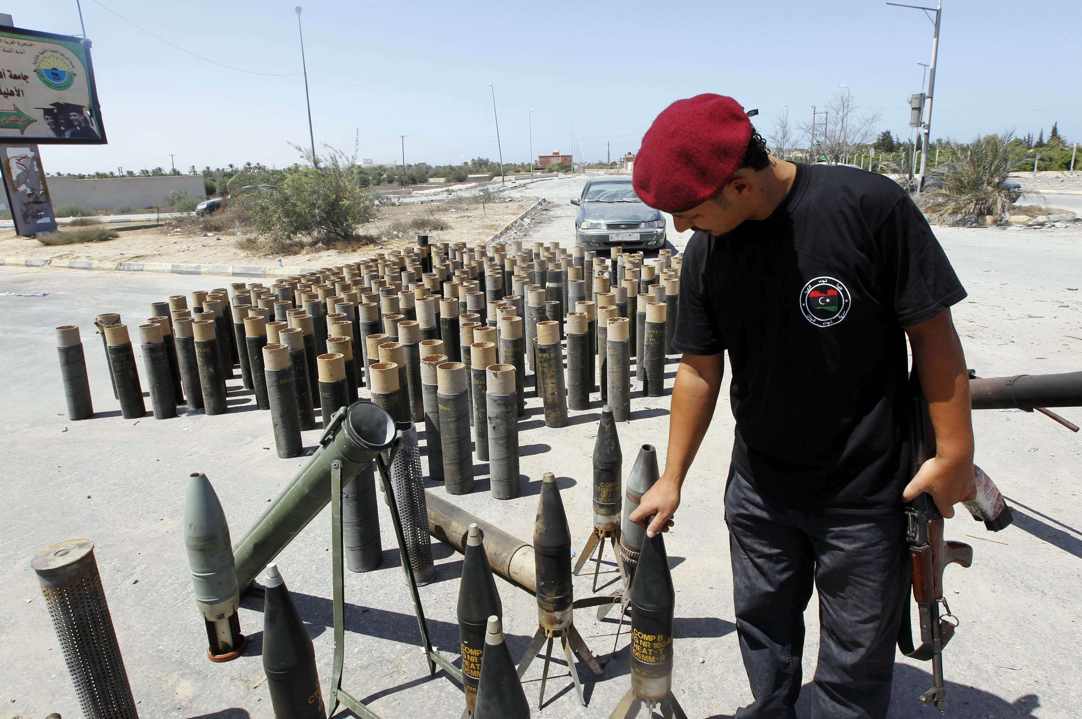 Rebelde reúne cartuchos que teriam sido usados pelas forçar pró-Kadafi em Zawiyah, cidade a 50 km de Trípoli | REUTERS/Louafi Larbi