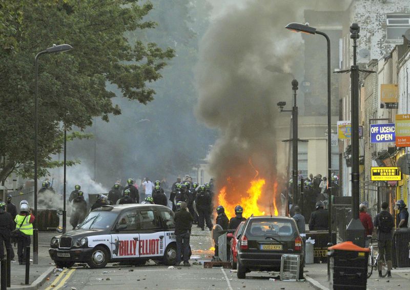 Policiais bloqueiam rua em Hackney, leste de Londres, após lojas serem saqueadas e carros incediados | Toby Melville/Reuters