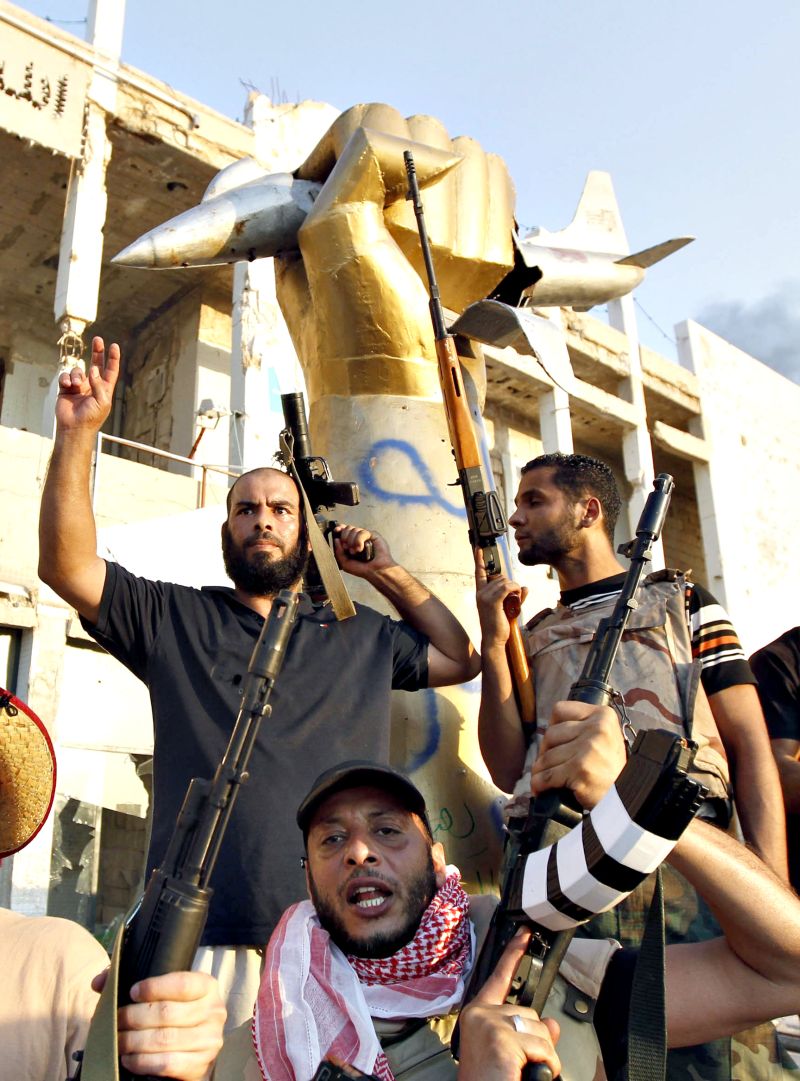 Rebeldes líbios celebram a conquista de Bab Al-Aziziya, o centro de poder do ditador Kadafi, em Trípoli | Louafi Larbi/Reuters