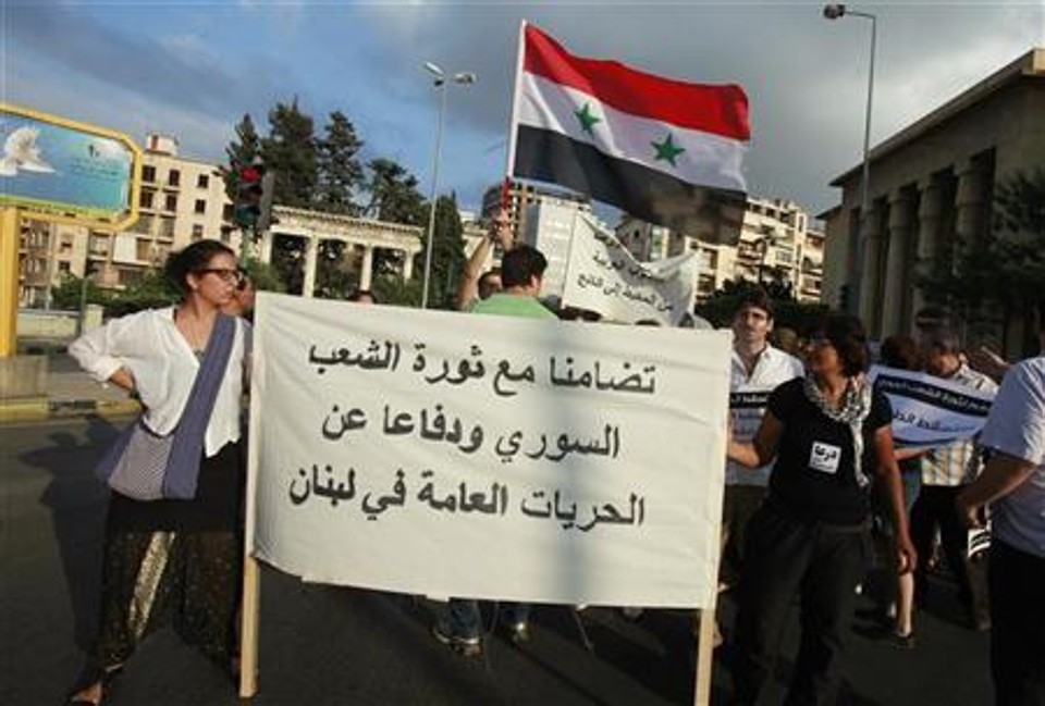 Ativistas com cartazes e a bandeira síria realizam protesto em solidariedade aos manifestantes na Síria, em Beirute, no Líbano. Tropas da Síria invadiram casas em um distrito sunita do porto de Latakia nesta quarta-feira, disseram moradores, prendendo centenas de pessoas e as levando para um estádio | REUTERS/Sharif Karim