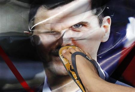 Na Turquia, manifestante da oposição pisa em cartaz do presidente sírio, Bashar al-Assad, durante protesto no centro da capital turca, Istambul. Veículos blindados sírios cercaram e fizeram disparos na segunda-feira em uma cidade na região onde dezenas de soldados haviam desertado, segundo ativistas e moradores | REUTERS/Murad Sezer