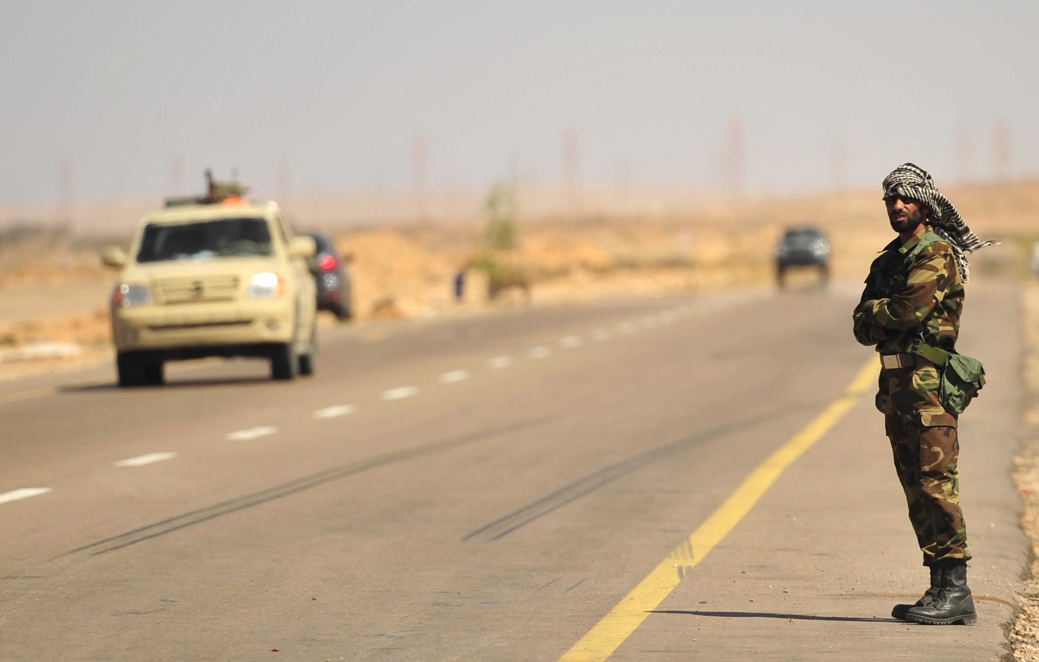 Rebelde líbio fiscaliza estrasa na área de Al-Noflea, a cerca de 450 km de Sirte, cidade-natal do ditador Muamar Kadafi | REUTERS/Esam Al-Fetori