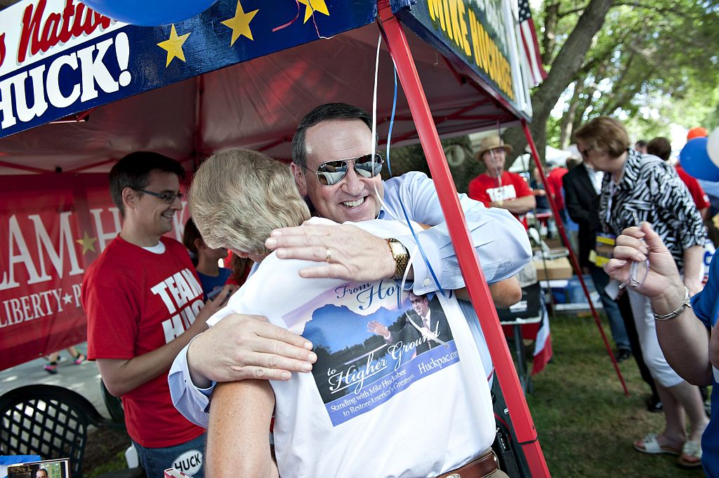 Mike Huckabee abraça eleitora durante a prévia em Iowa | Reuters