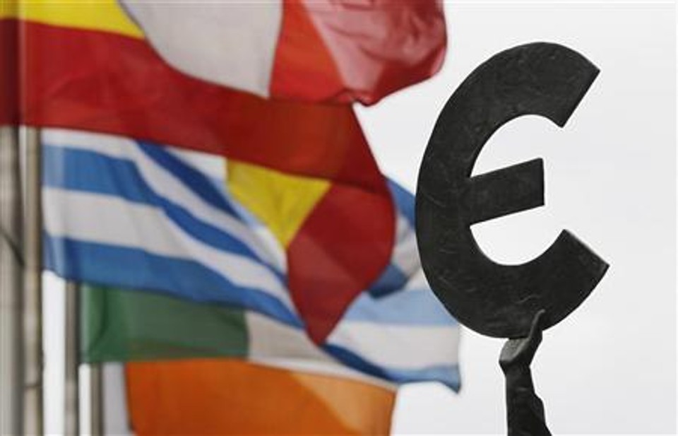 Bandeiras de países da UE tremulam perto de um símbolo do euro em frente do Parlamento Europeu, em Bruxelas | REUTERS/Francois Lenoir