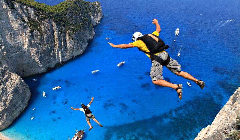 Marcelo Barros Wendt, o Kiko (de branco), salta do penhasco na ilha de Kakynthos, na Grécia, onde conquistou o quinto lugar no Mundial de base jump | Divulgação