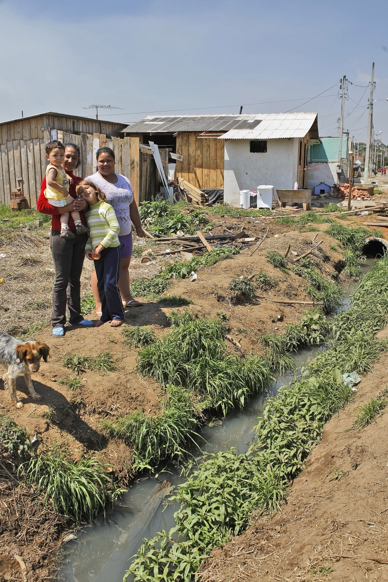 Lovaine Loures Souza com os filhos: riqueza de Araucária passa longe do bairro onde ela mora | Jonathan Campos/ Gazeta do Povo