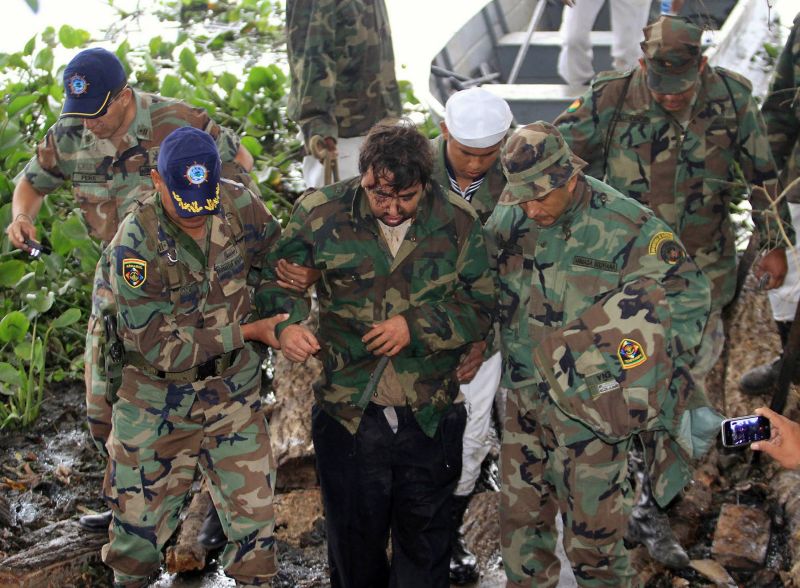 Membros do exército ajudam Minor Vidal (centro), único sobrevivente da queda de um pequeno avião comercial na Bolívia | Stringer/ Reuters