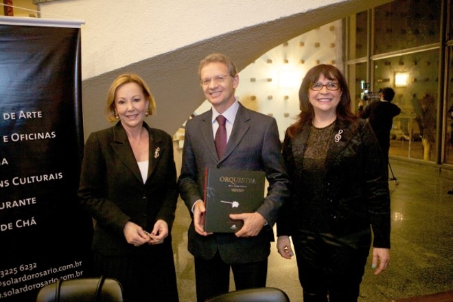 As autoras Clarice Miranda (à esq.) e Liana Justus receberam o presidente da Incepa, Celso Cavalli, para o lançamento do livro Orquestra no saguão do Teatro Guaíra, em evento promovido pelo Solar do Rosário. Após a sessão de autógrafos, a Orquestra Sinfônica do Paraná fez uma apresentação aos convidados |