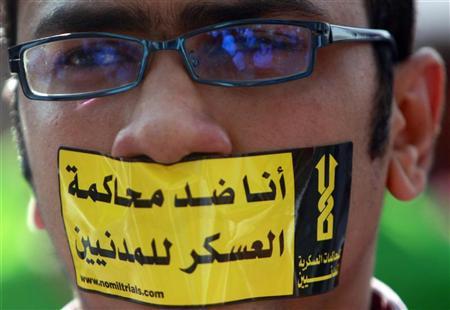 Manifestante usa adesivo na boca que lê "Eu sou contra cortes militares para civis" na praça Tahrir, no Cairo, Egito | REUTERS/Amr Abdallah Dalsh