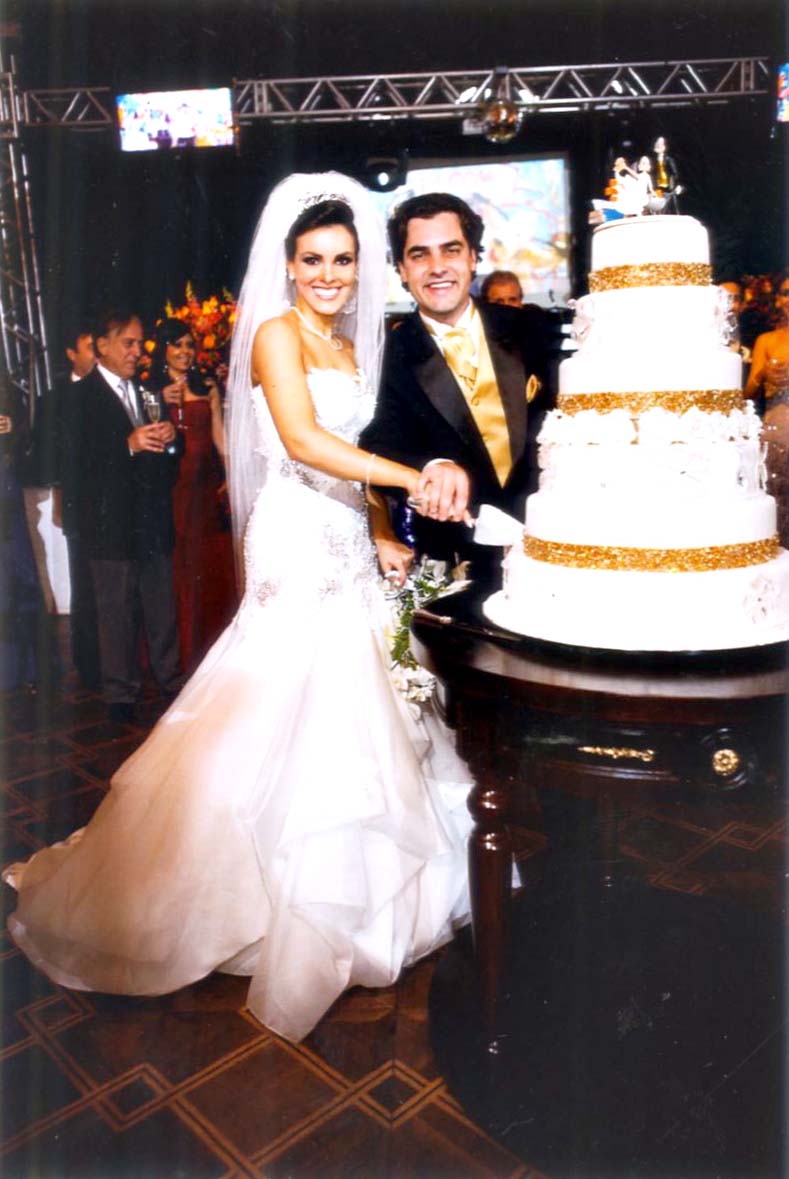 Os noivos Roberta Serena e Kristofer Florenzano, na cerimônia que os uniu, no Clube Concórdia, cortam o bolo de casamento, obra de Sonia Bacelar | Kobiyama