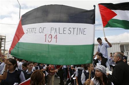 Estudantes palestinos seguram bandeiras ao chegar para entregar cartas destinadas ao secretário-geral da ONU, Ban Ki-moon, por meio do escitório da ONU em Ramallah, na Cisjordânia. O ministro palestino das Relações Exteriores expressou confiança nesta terça-feira de que sua delegação vai angariar o mínimo de nove votos necessários para obter o apoio do Conselho de Segurança da Organização das Nações Unidas (ONU) a um Estado palestino | REUTERS/Mohamad Torokman