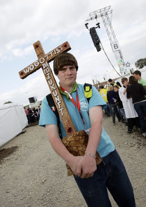Fiel carrega cruz com os dizeres O futuro está onde Deus existe, durante visita do Papa à Alemanha | Kai Pfaffenbach/Reuters