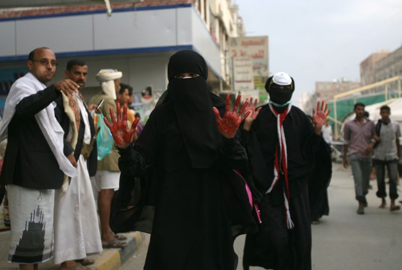 Mulher mostra mãos sujas de sangue por ajudar um colega protestante | AFP