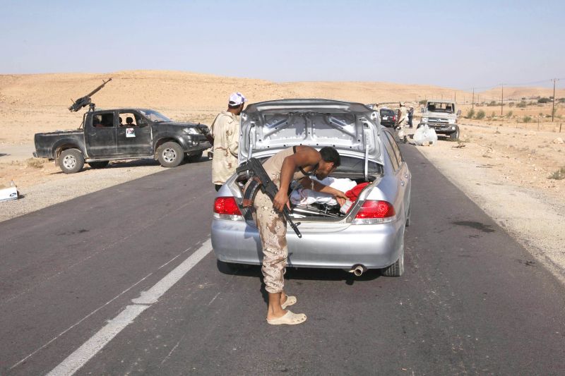 Rebelde revista carro de civil em rodovia de acesso a Bani Walid, cidade que ainda está sob o controle das forças de Kadafi | Youssef Boudlal/Reuters