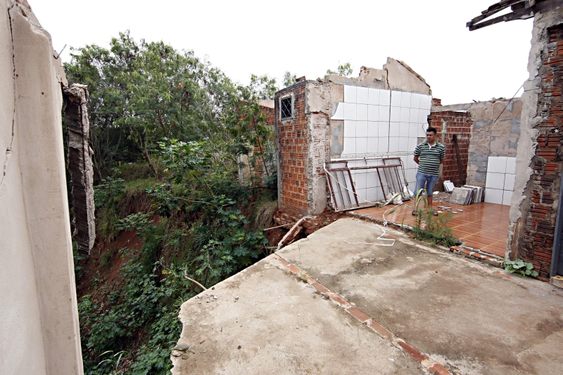 Edivaldo, comerciante do Jardim Paulista, mostra o que sobrou de uma casa que foi engolida pela erosão | Fotos: Albari Rosa/ Gazeta do Povo