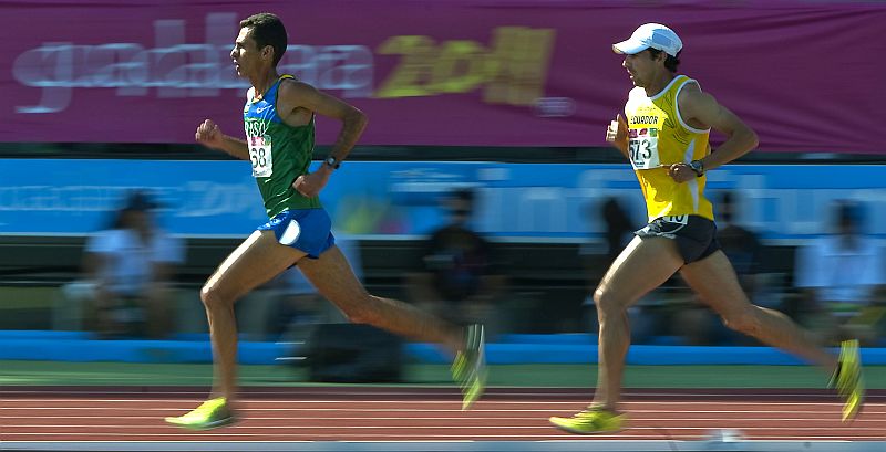 Marilson Gomes dos Santos, de verde, ultrapassa equatoriano no início da prova dos 10 mil metros: brasileiro disparou após os 4 km | Luis Acosta / AFP