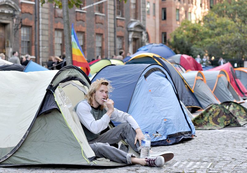 Acampado escova os dentes em barraca no centro de Londres. Manifestantes prometem permanecer no local enquanto não forem ouvidos | Carl Court/AFP