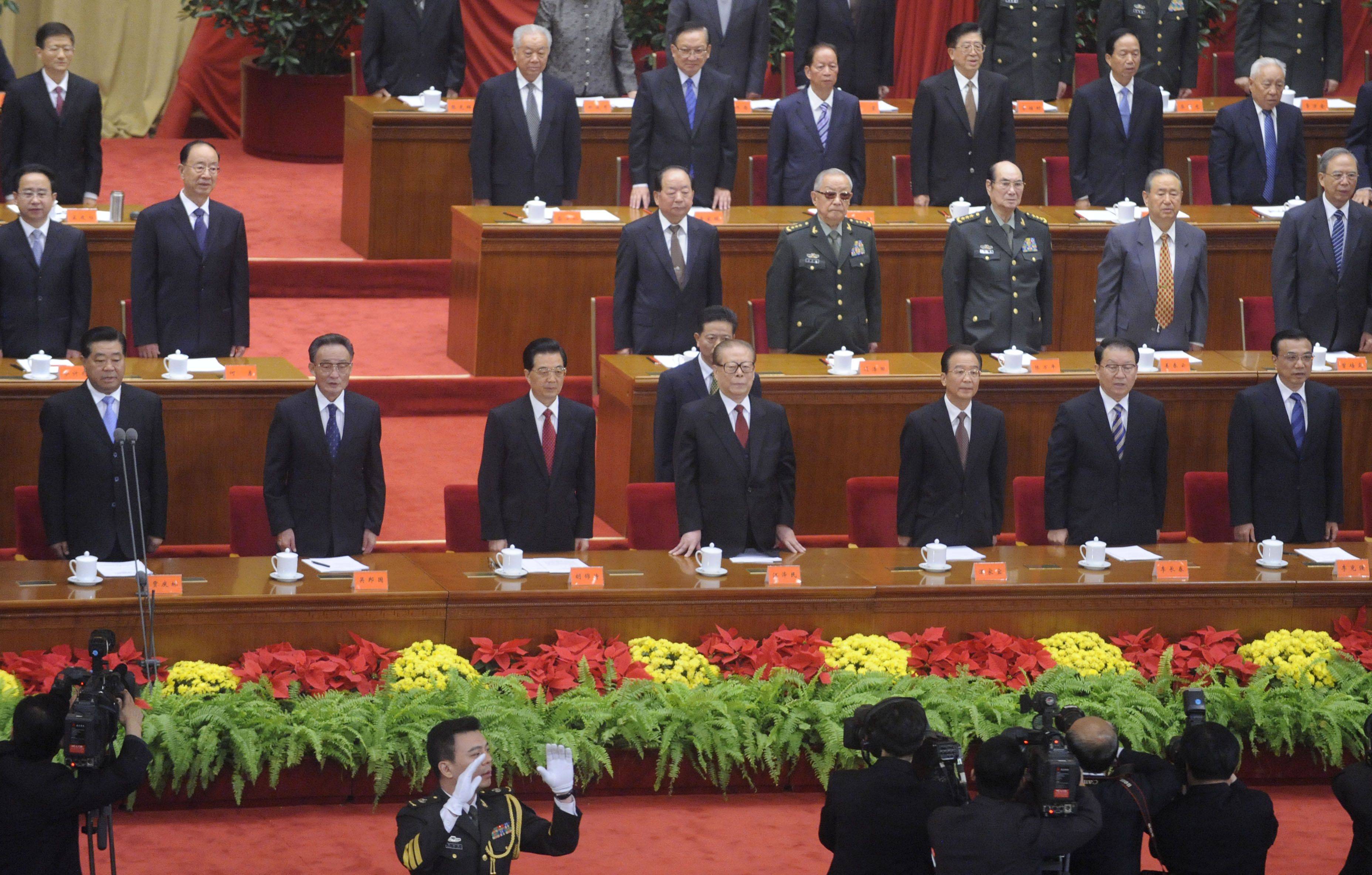 Presidente chinês Hu Jintao (3.º à esquerda), ex-presidente Jiang Zemin (centro) e o premiê Wen Jiabao (3.º à direita)cantam o hino nacional durante cerimônia no Grande Salão do Povo em Pequim | AFP PHOTO / POOL / MINORU IWASAKI