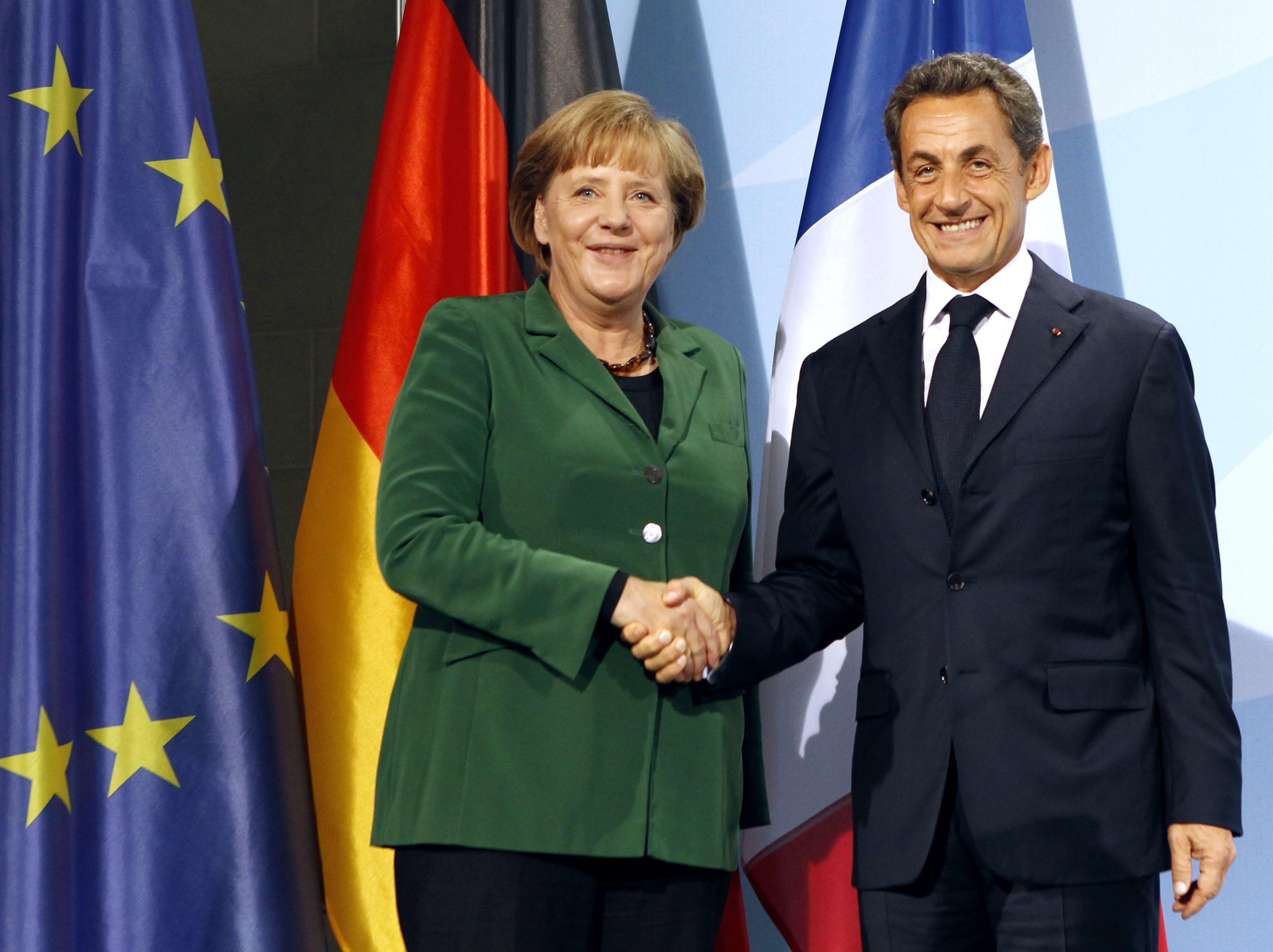 Presidente francês Nicolas Sarkozy e a chanceler alemâ Angela Merkel se cumprimenram após participar de coletiva de imprensa em Berlim | REUTERS/Fabrizio Bensch