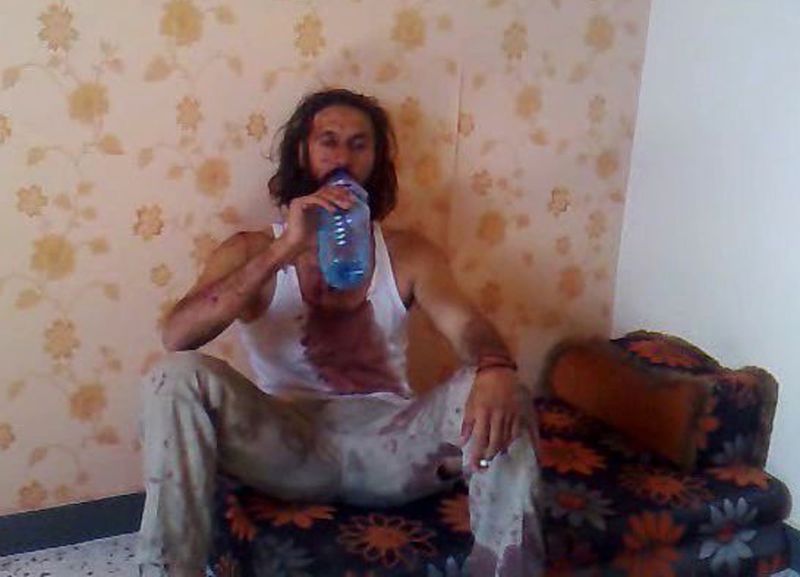 Muatasim, um dos filhos de Kadafi, bebe água e fuma antes de morrer | AFP