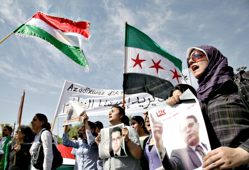 Manifestantes
seguram fotos de Mechaal Tamo, assassinado na última sexta-feira: protestos em cidades sírias já duram sete meses | Reuters