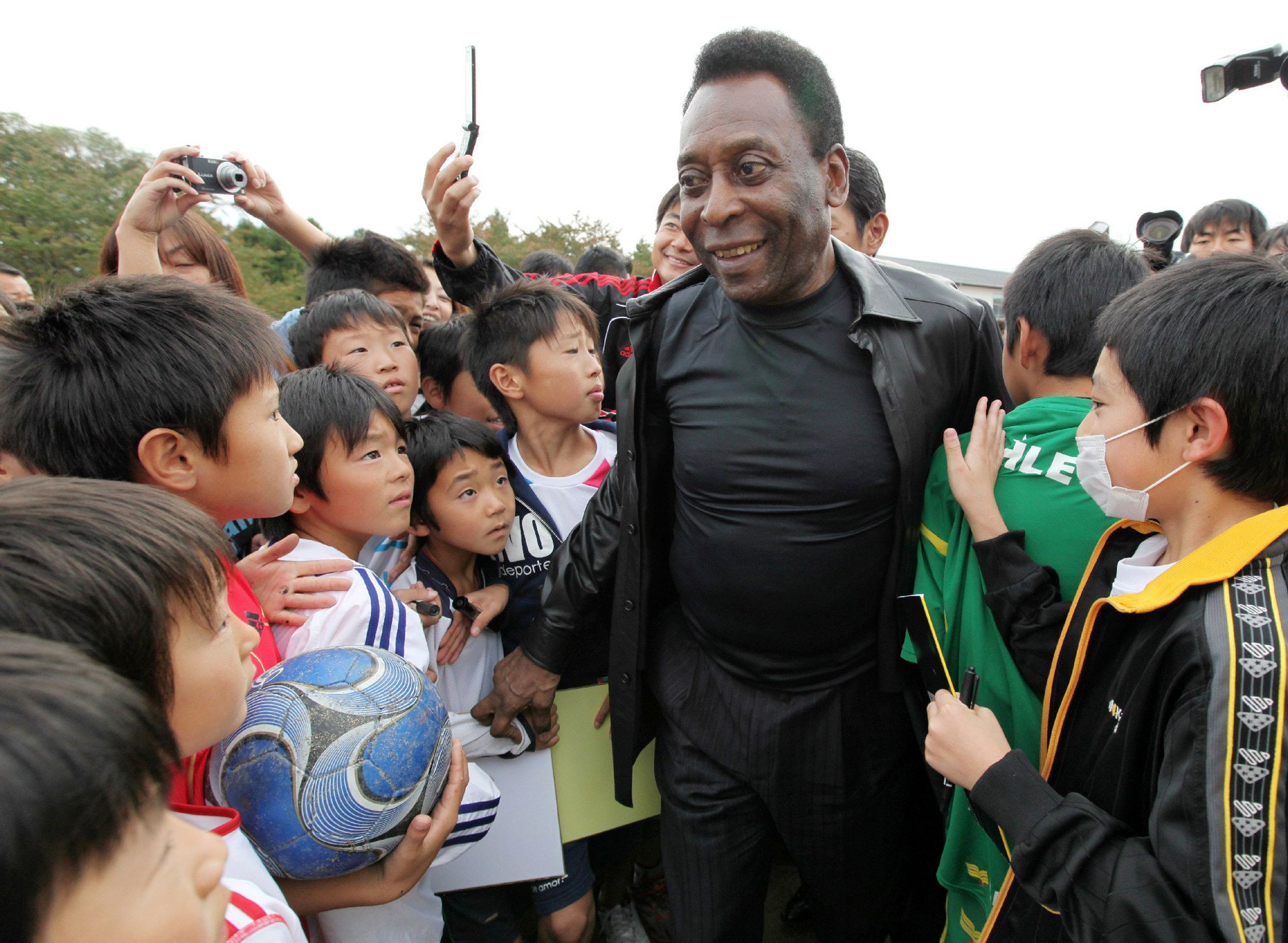 O ídolo brasileiro distribuiu autógrafos e bolas de futebol para as crianças. Além disso, entregou doações de empresas brasileiras, como cobertores, para os moradores da região | AFP PHOTO / JIJI PRESS