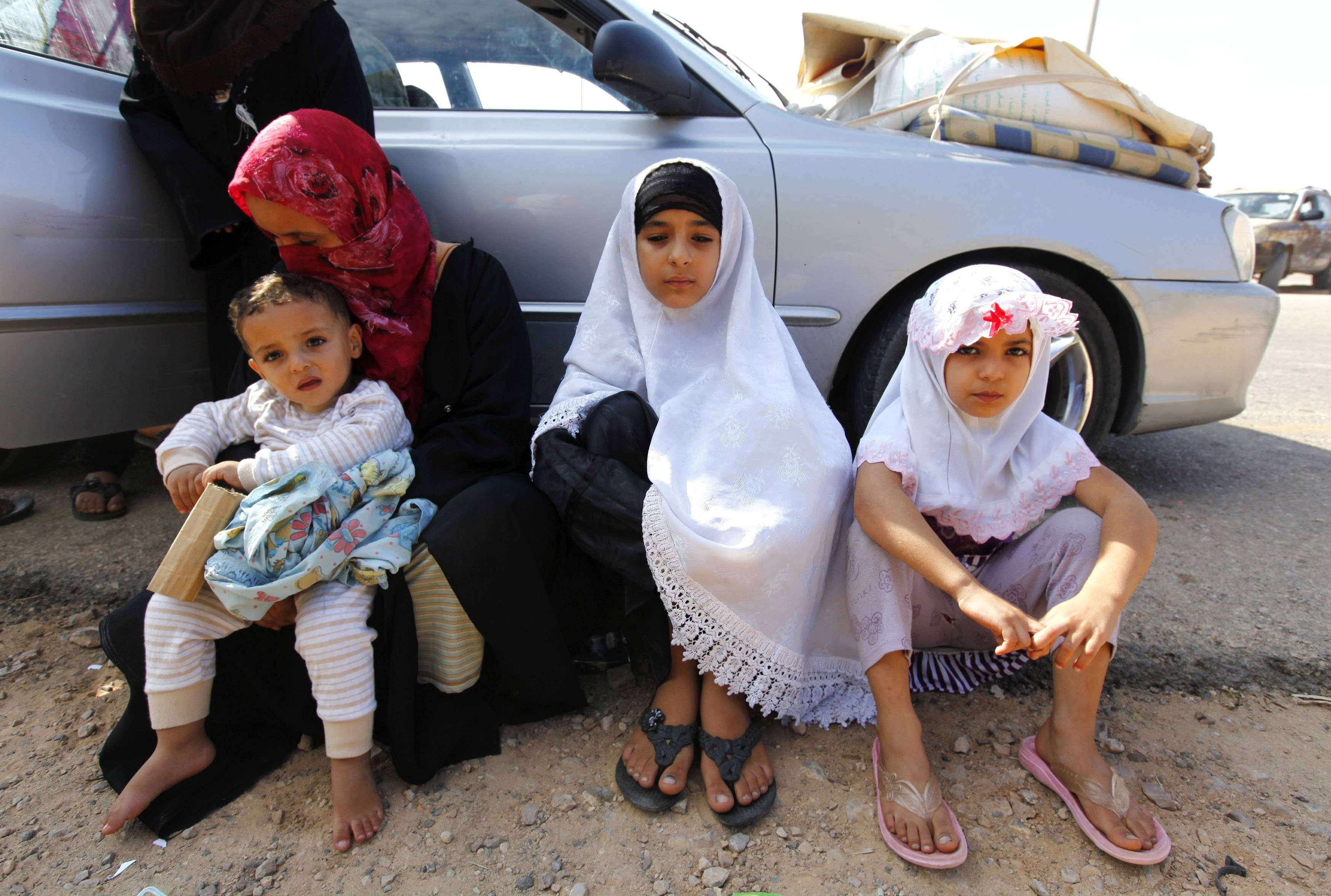 Mãe e suas filhas fogem de Sirte, na Líbia | REUTERS/Anis Mili