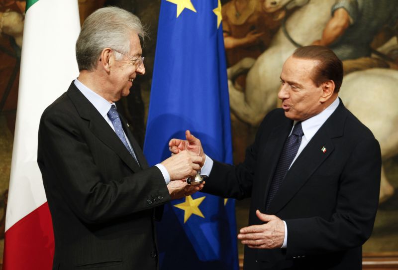 Mario Monti (à esquerda) recebe de Berlusconi o sino usado pelos primeiros-ministros para iniciarem reuniões de gabinete | Stefano Rellandini/Reuters