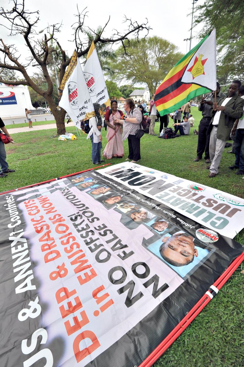 Ativistas protestam em frente do local onde se realiza a conferência sobre clima das Nações Unidas, em Durban | Alexander Joe/AFP