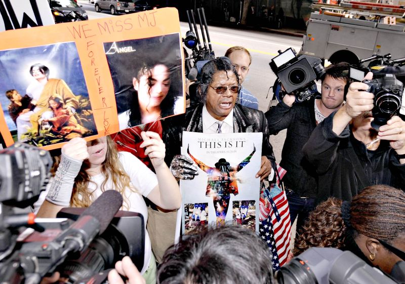 Fãs de Michael Jackson exibem cartazes com fotos do cantor durante o julgamento em Los Angeles | Gus Ruelas/Reuters