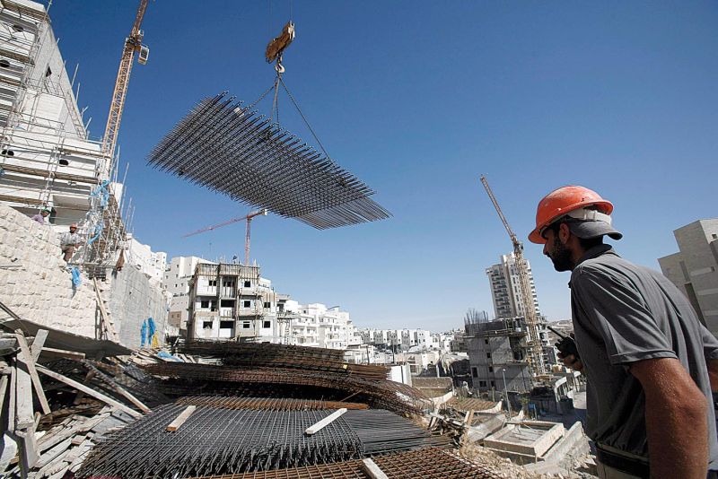 Operário palestino trabalha na construção de assentamento israelense em território ocupado | Baz Ratner/Reuters