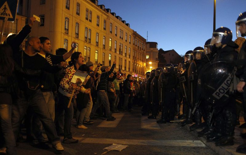 Manifestantes gritam palavras de ordem diante dos policiais em frente ao parlamento em Lisboa | Rafael Marchante/Reuters