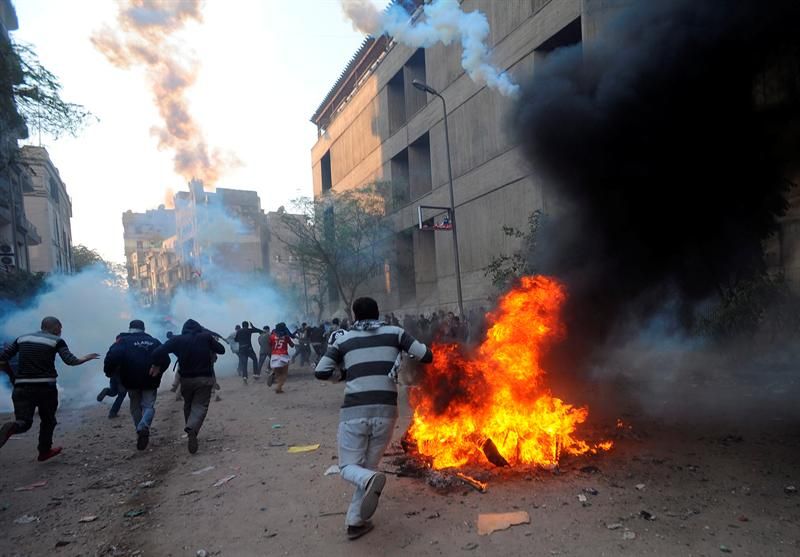 Grupo de manifestantes entram em confronto com as forças de segurança na Praça Tahrir | EFE/MOHAMED OMAR