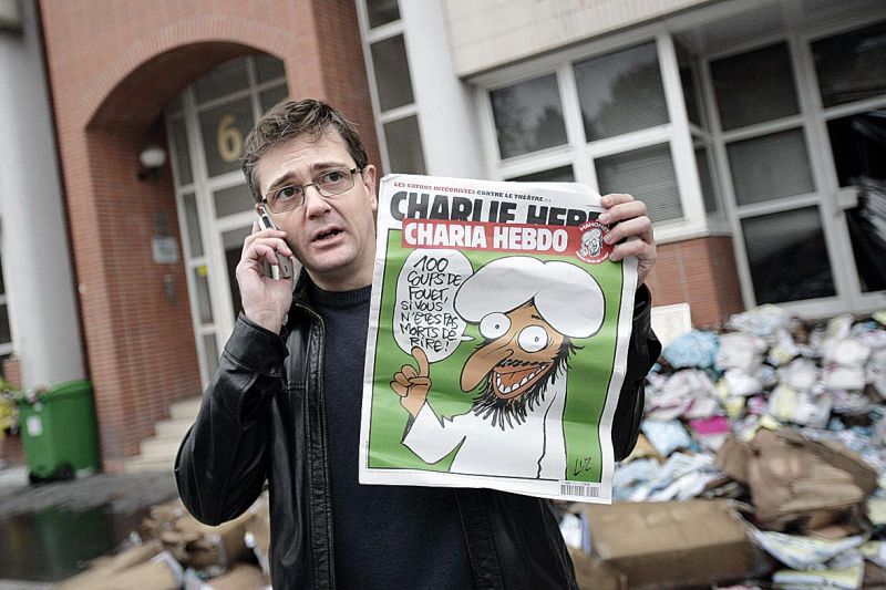 O editor Stephane Charbonnier mostra capa da revista que provocou ataque | Alexander Klein/AFP